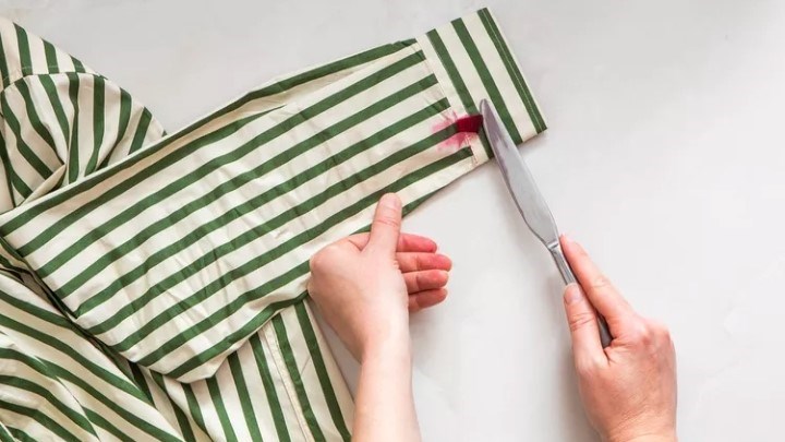 مرحله اول پاک کردن لکه لبو از لباس؛ برداشتن تکه لبو با چاقو کند مرحله اول پاک کردن لکه لبو از لباس؛ برداشتن تکه لبو با چاقو کند